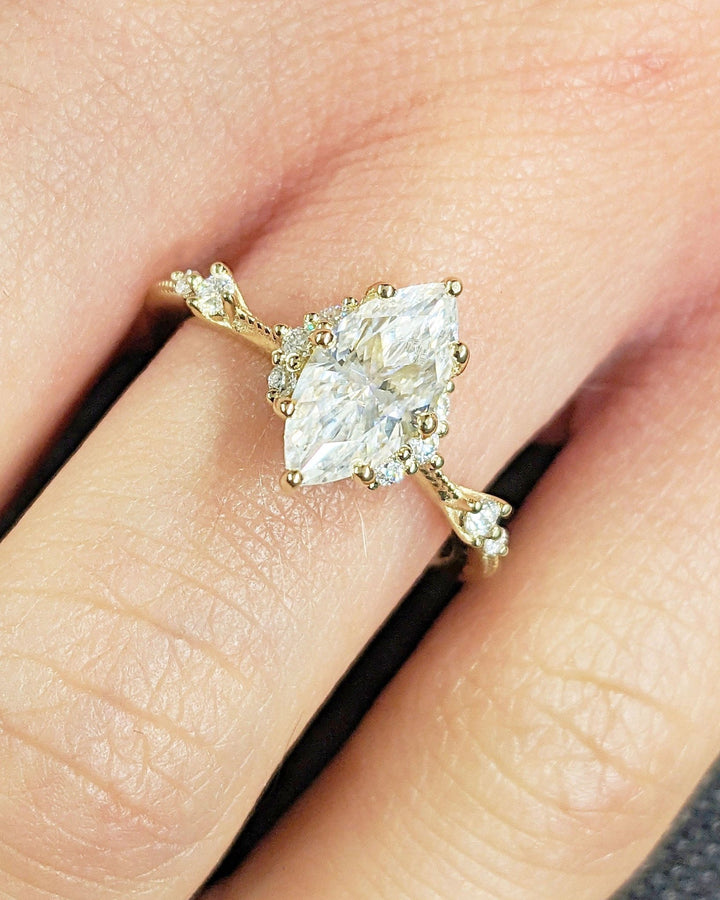 Close-up of marquise cut center diamond in cluster engagement ring