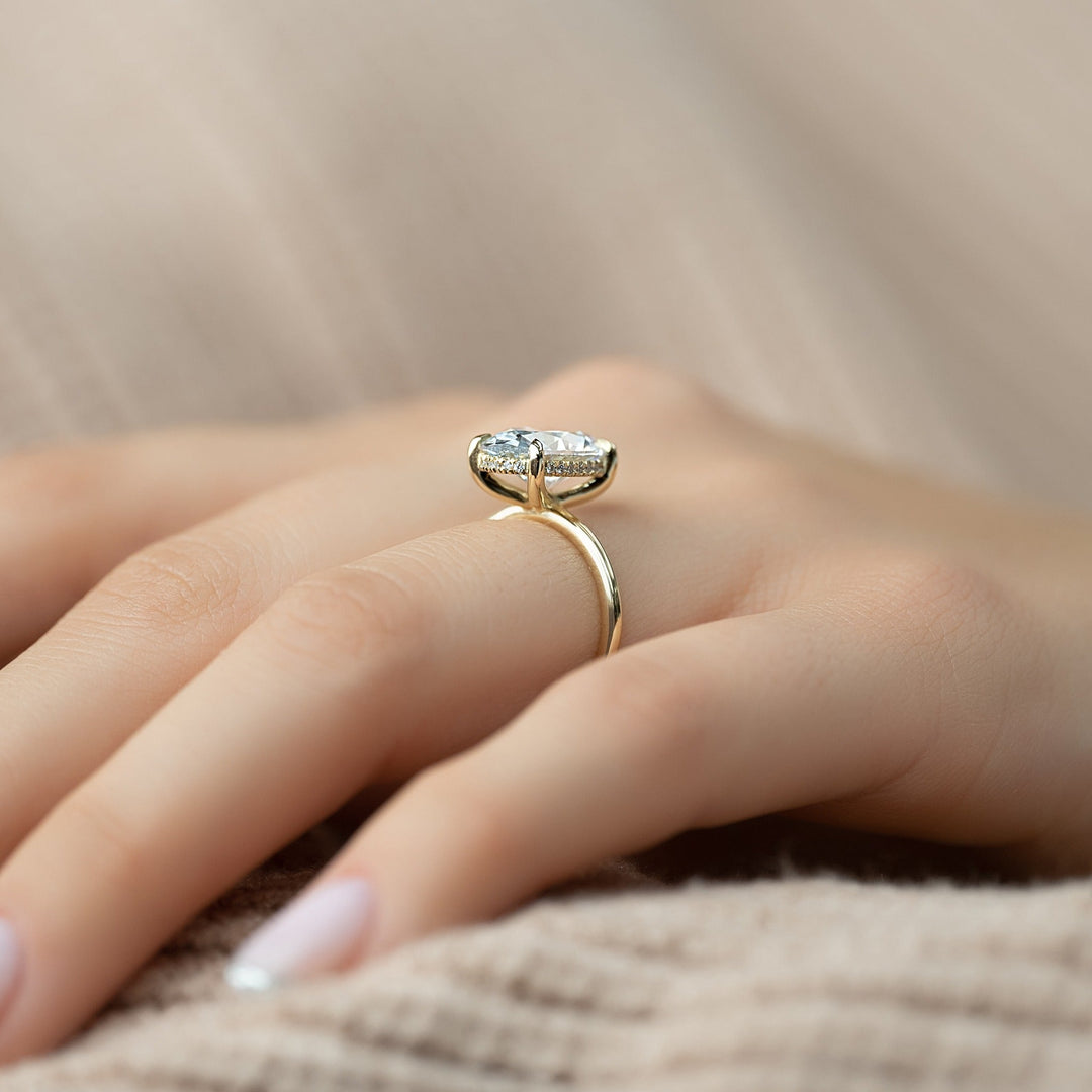 Oval hidden halo engagement ring offered in gold and platinum