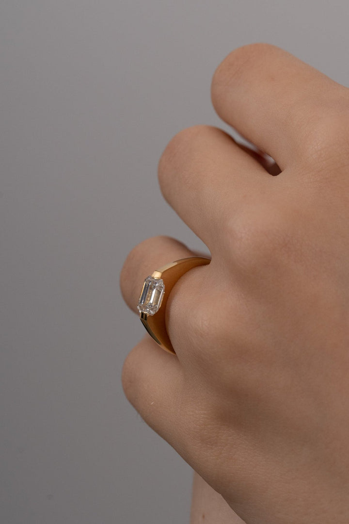 Certified emerald cut diamond featured in east west engagement ring