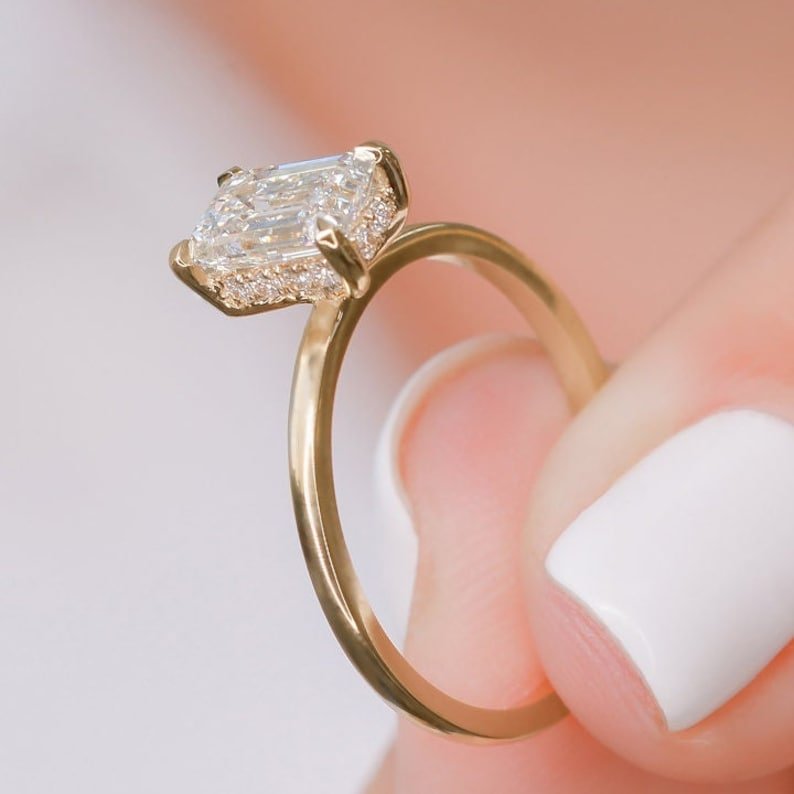 Side angle of emerald hidden halo diamond engagement ring