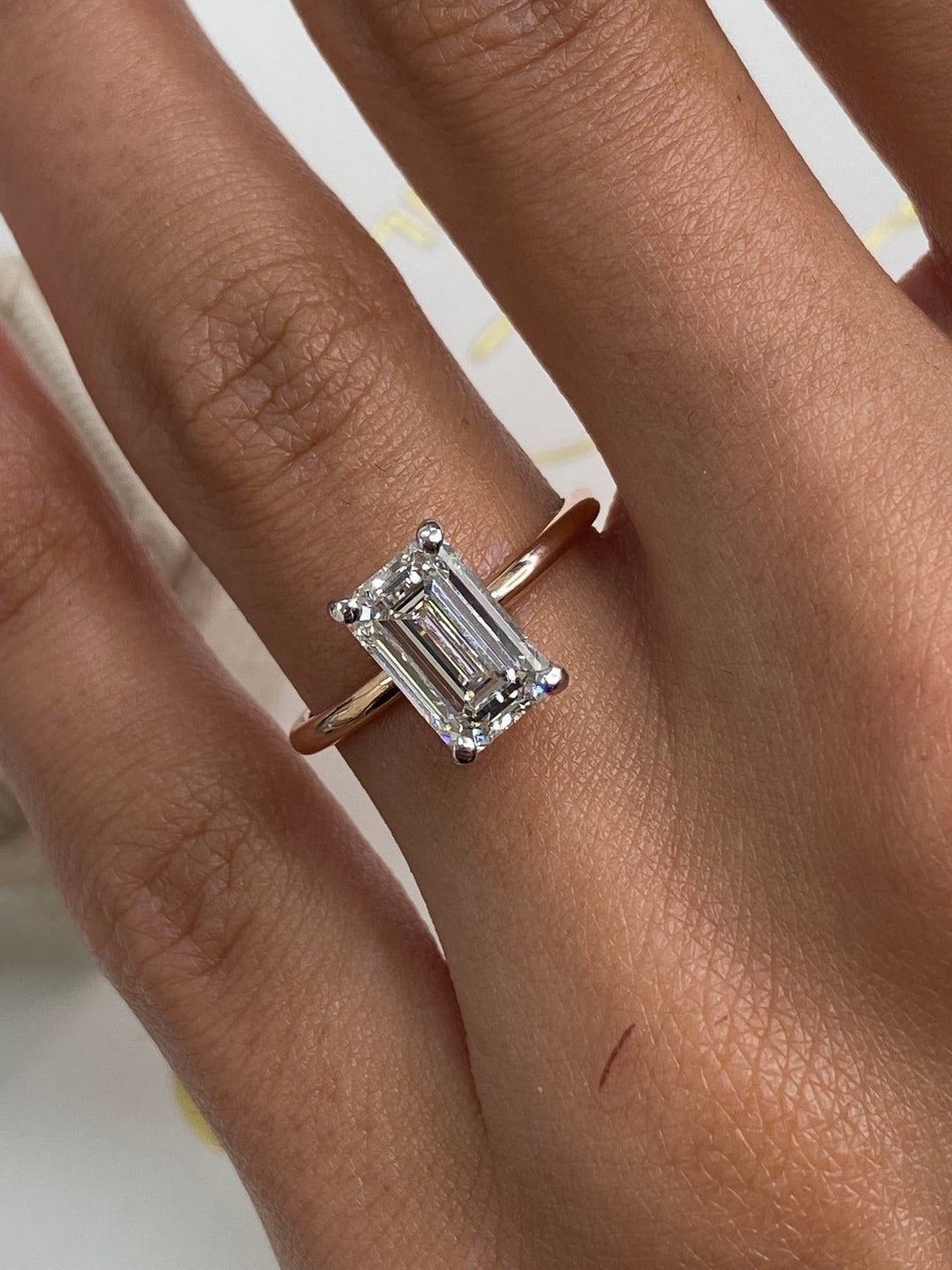 Emerald cut engagement ring shown with authenticity certificate