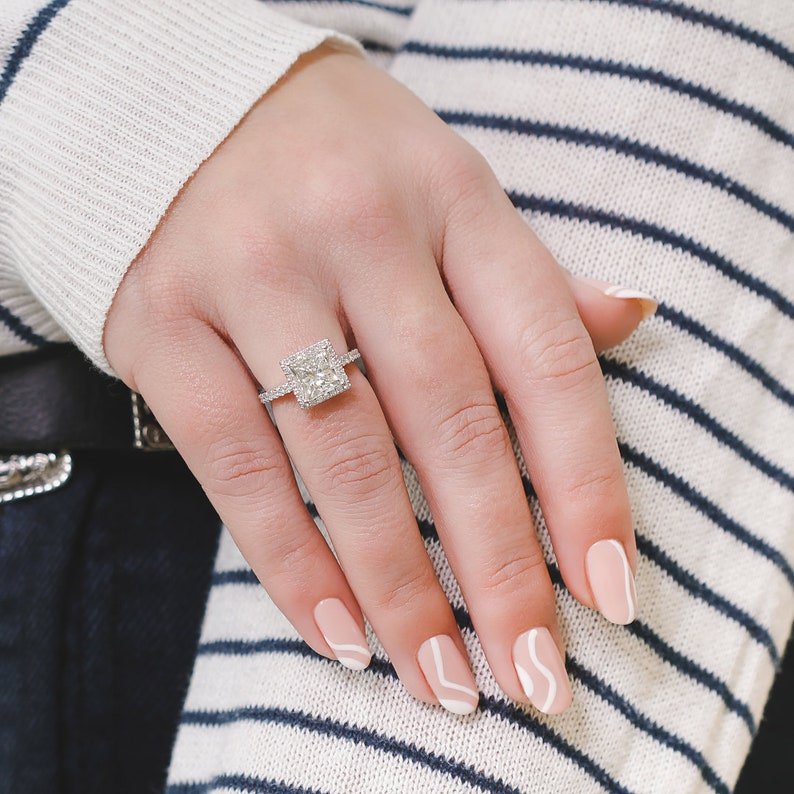 Princess cut engagement ring shown with authenticity certificate