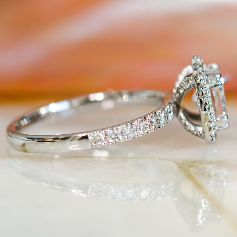 Cushion halo engagement ring shown on hand for true-to-life sizing