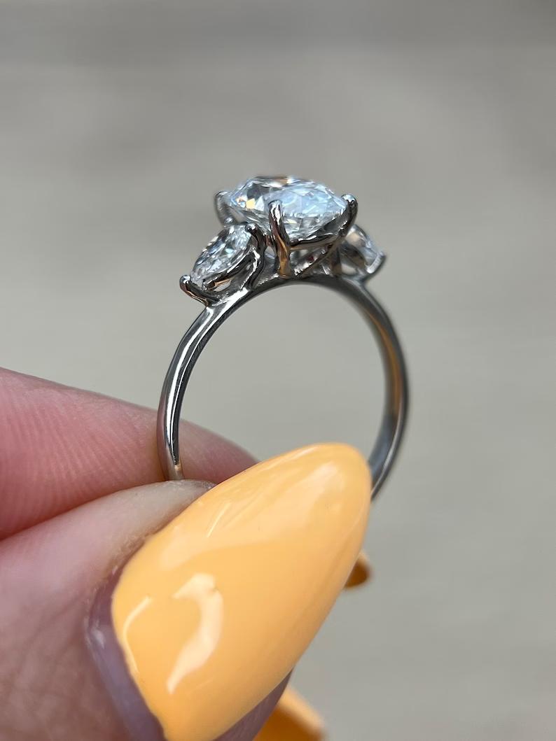 Oval three stone engagement ring shown on hand for true-to-life sizing