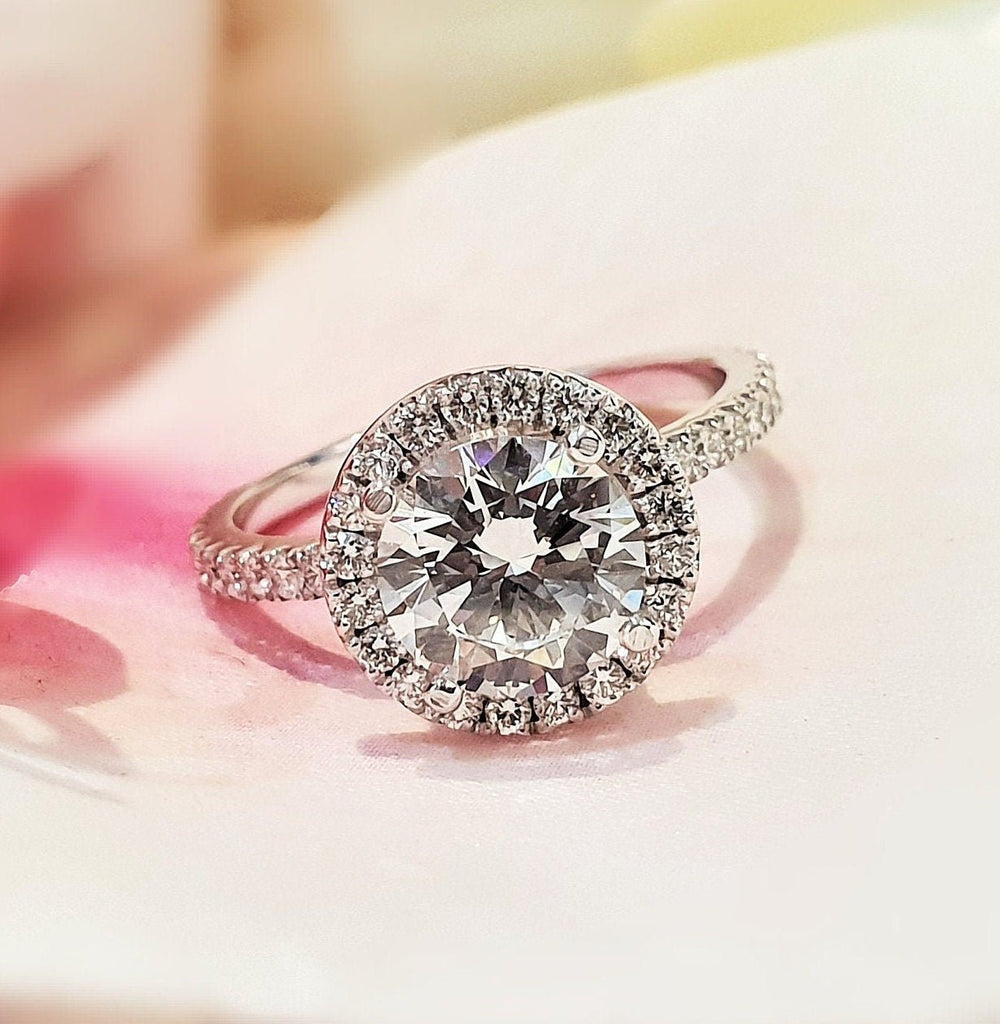 Round halo diamond ring displayed on jewelry stand