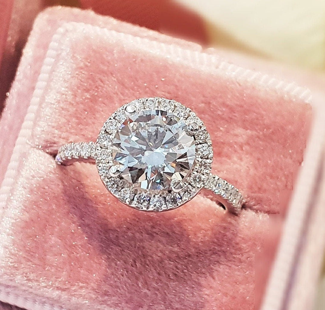 Close-up of round cut center diamond in halo engagement ring
