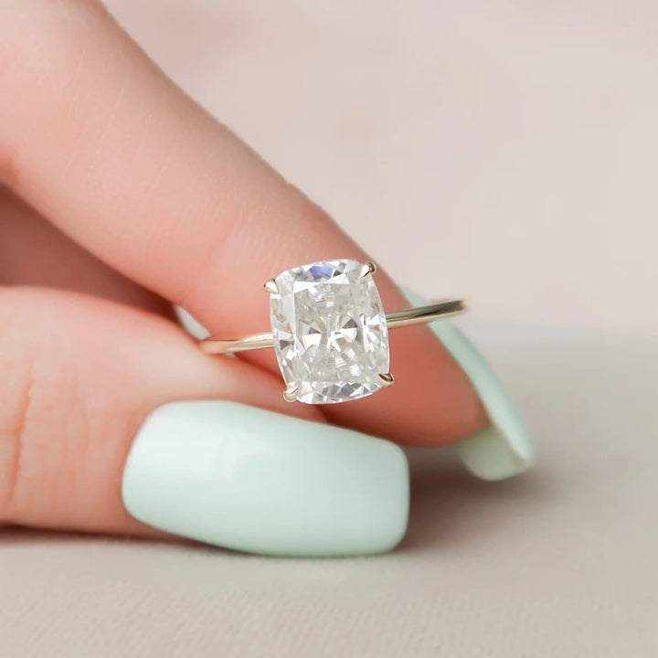 Cushion hidden halo engagement ring shown on hand for true-to-life sizing