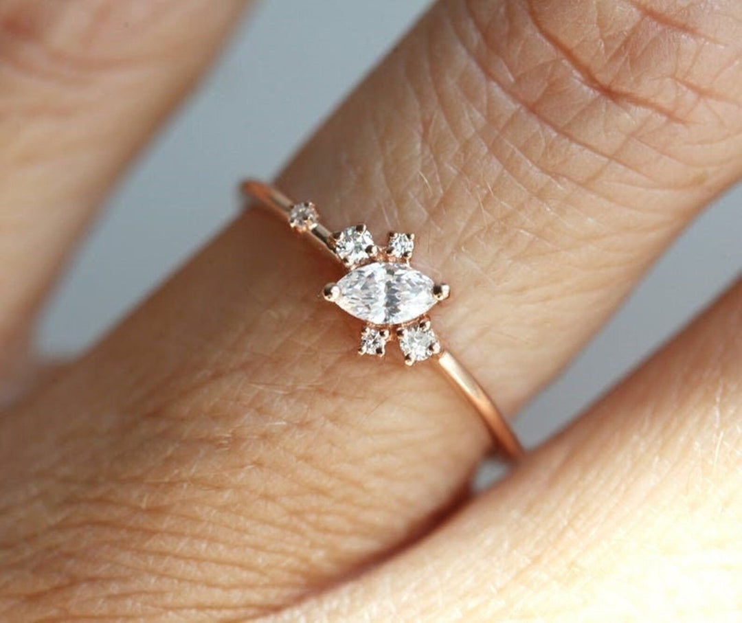Marquise cluster engagement ring shown on hand for true-to-life sizing