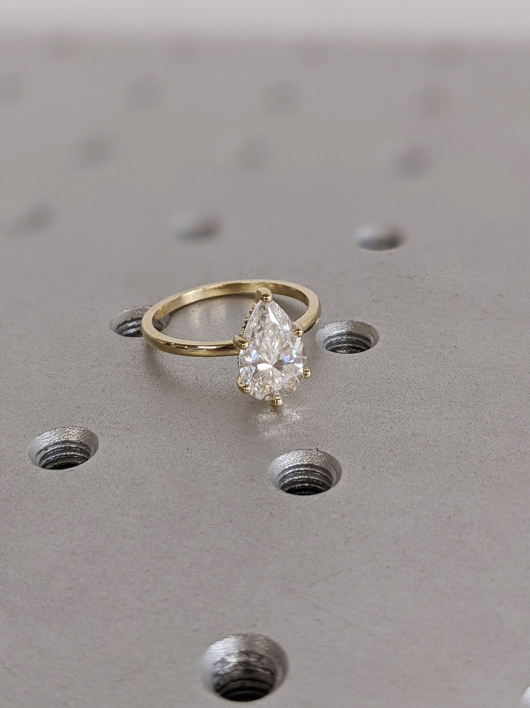 Pear hidden halo engagement ring close-up showing high clarity diamond clarity