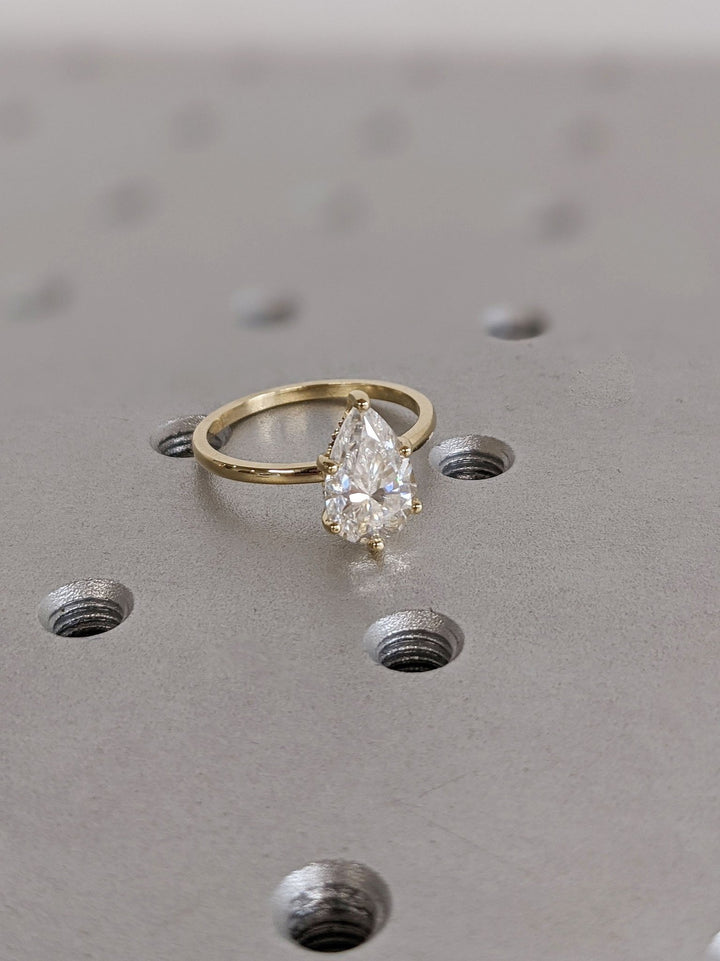 Pear hidden halo engagement ring close-up showing high clarity diamond clarity