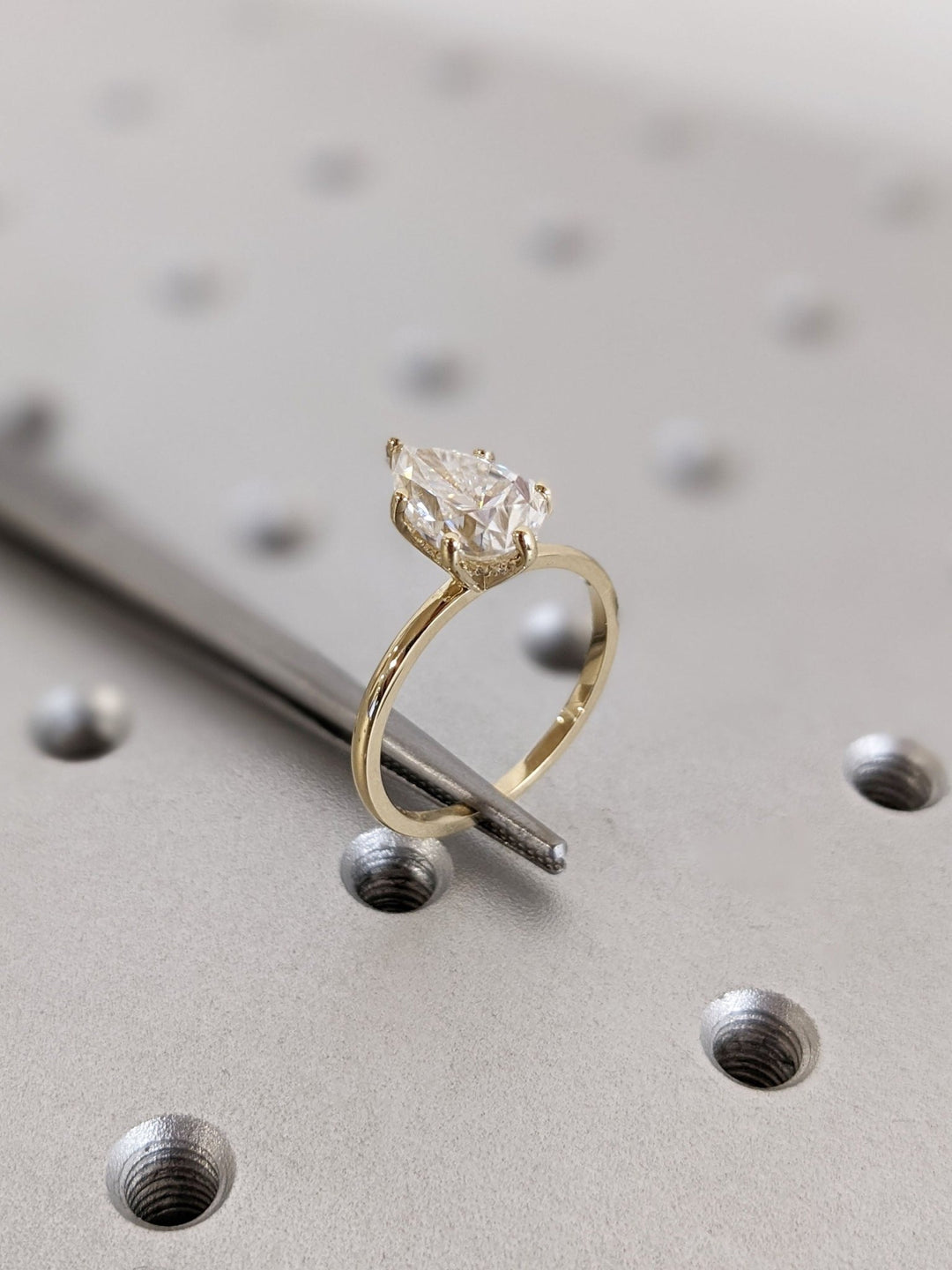 Pear hidden halo engagement ring close-up highlighting diamond sparkle
