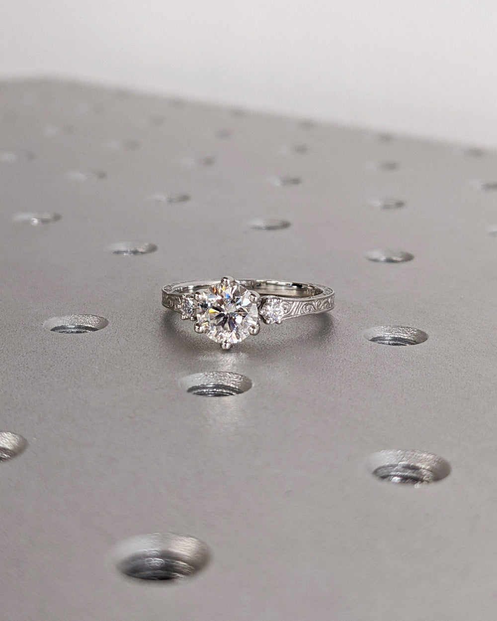 Detailed close-up of round three stone diamond engagement ring