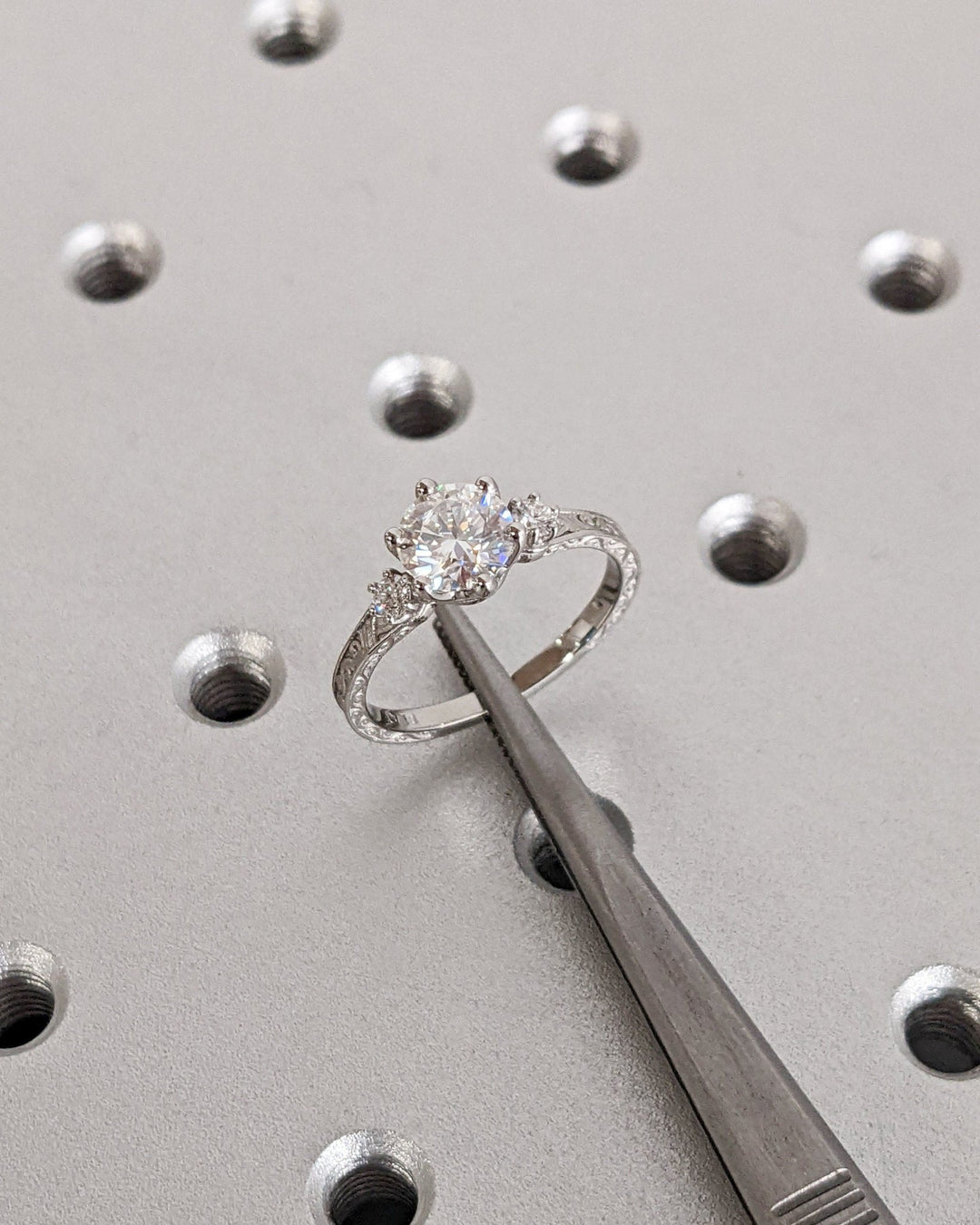 Round three stone engagement ring viewed from the side