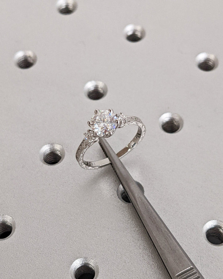 Round three stone engagement ring viewed from the side
