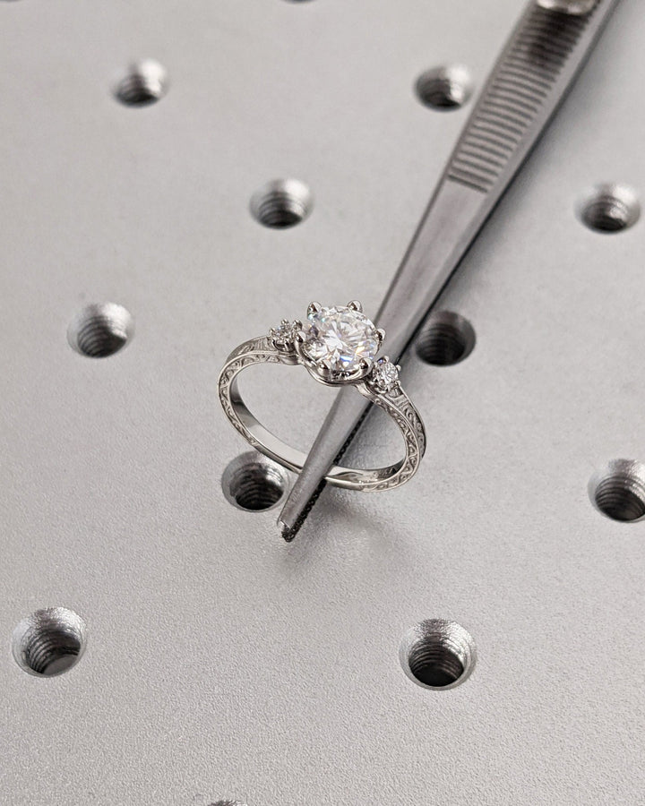 Round three stone engagement ring shown on hand for true-to-life sizing