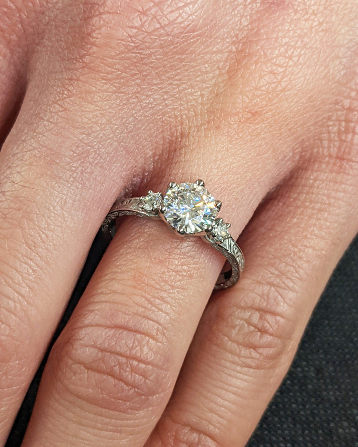 Profile view of round cut three stone engagement ring band