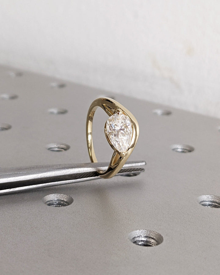Pear cut engagement ring shown with authenticity certificate
