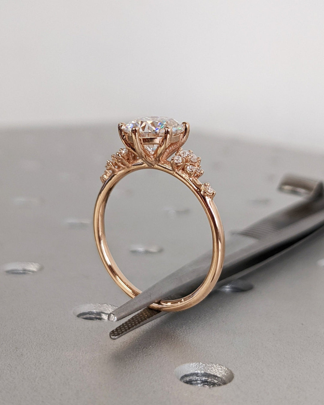 Round cluster engagement ring shown on hand for true-to-life sizing