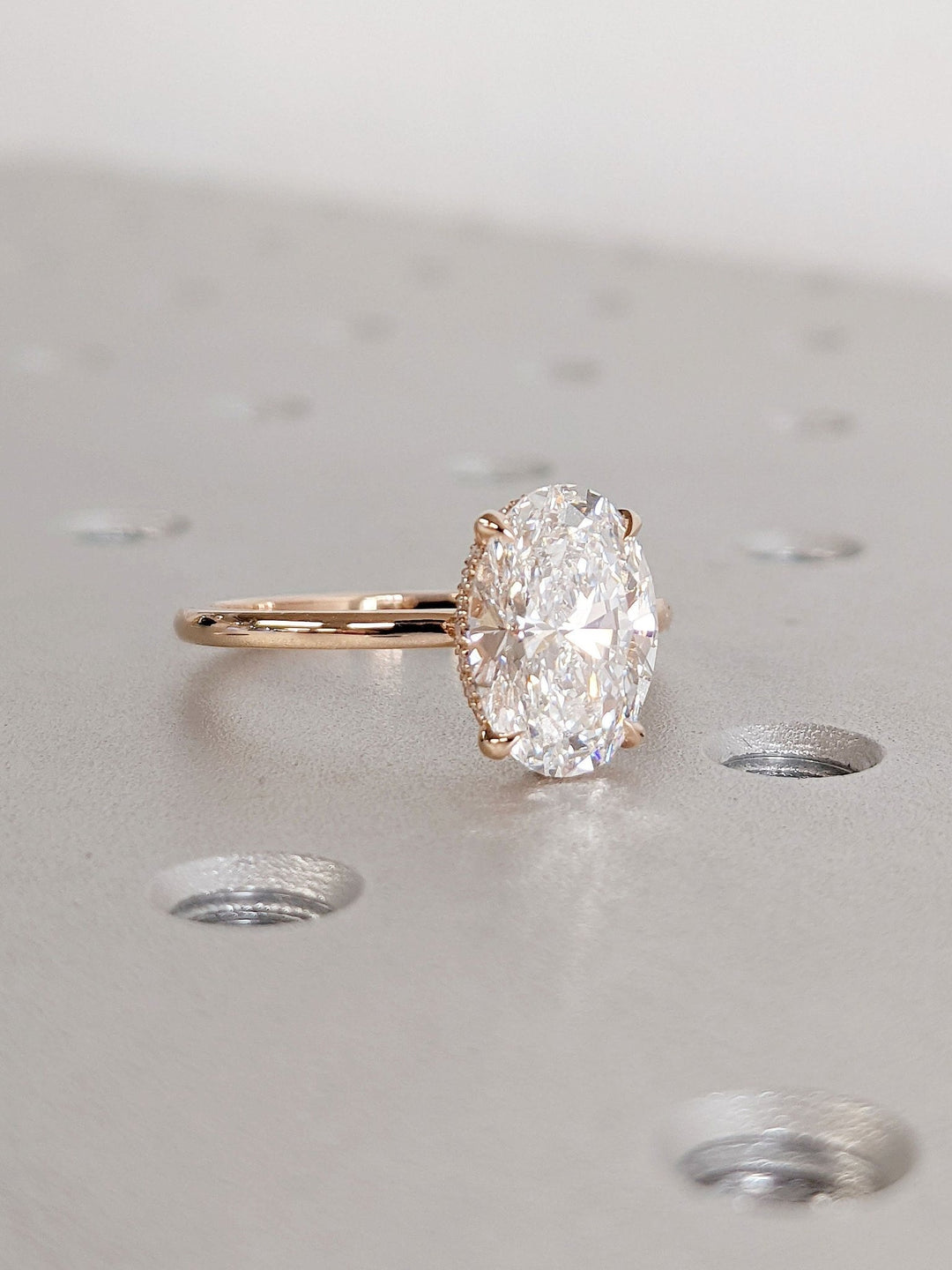 Oval hidden halo lab grown diamond ring fitted on finger