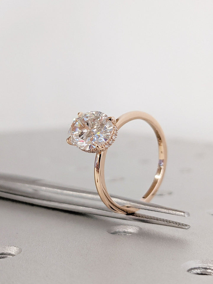 Lifestyle shot of oval hidden halo diamond ring on hand