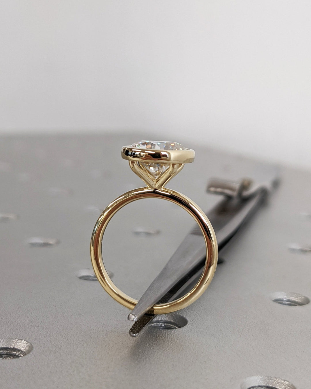 Round cut bezel engagement ring shown in real-life wear