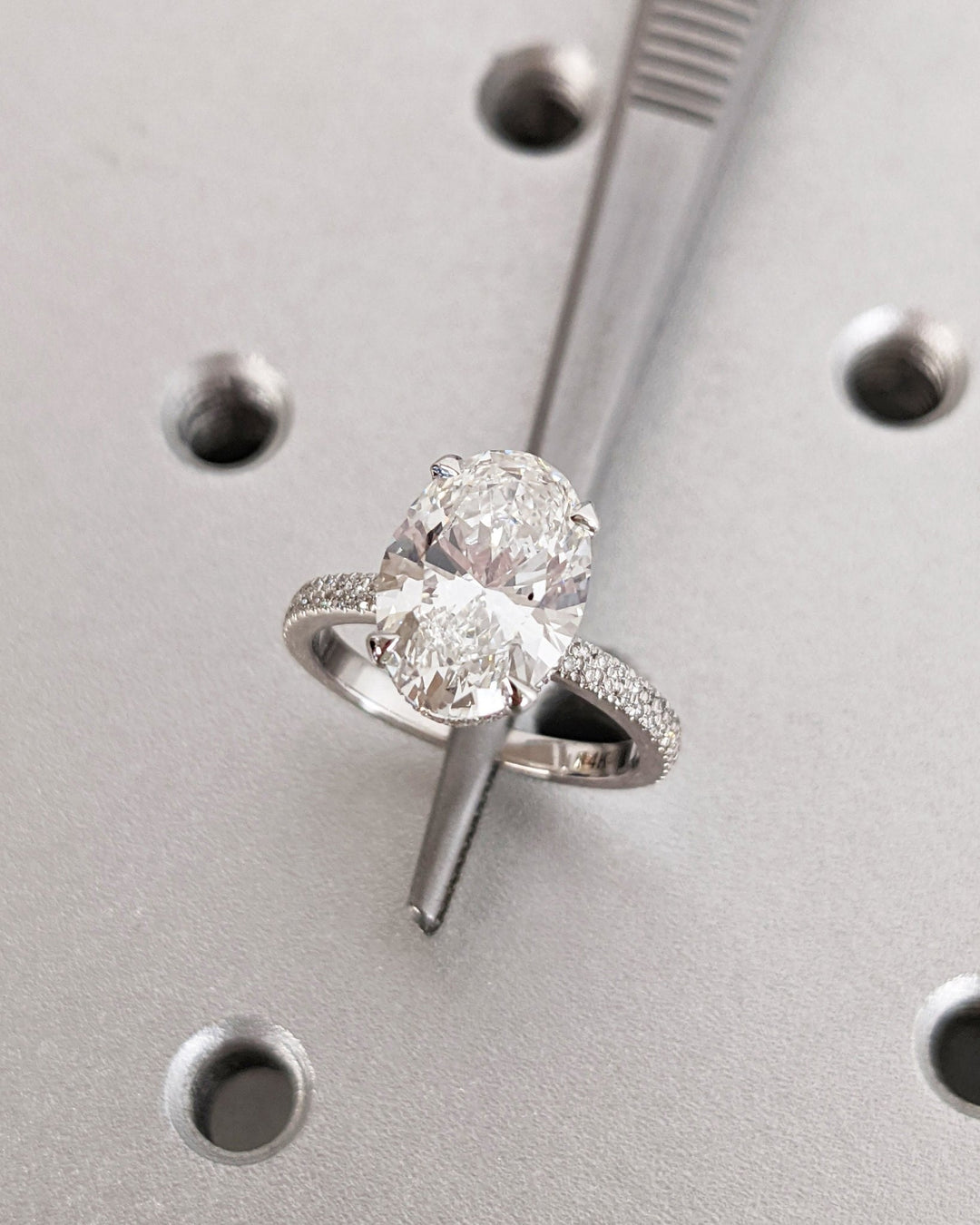 Oval hidden halo engagement ring offered in gold and platinum