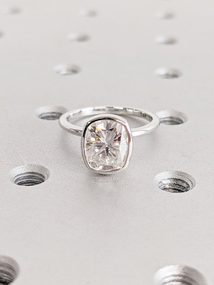 Cushion bezel diamond ring displayed on jewelry stand