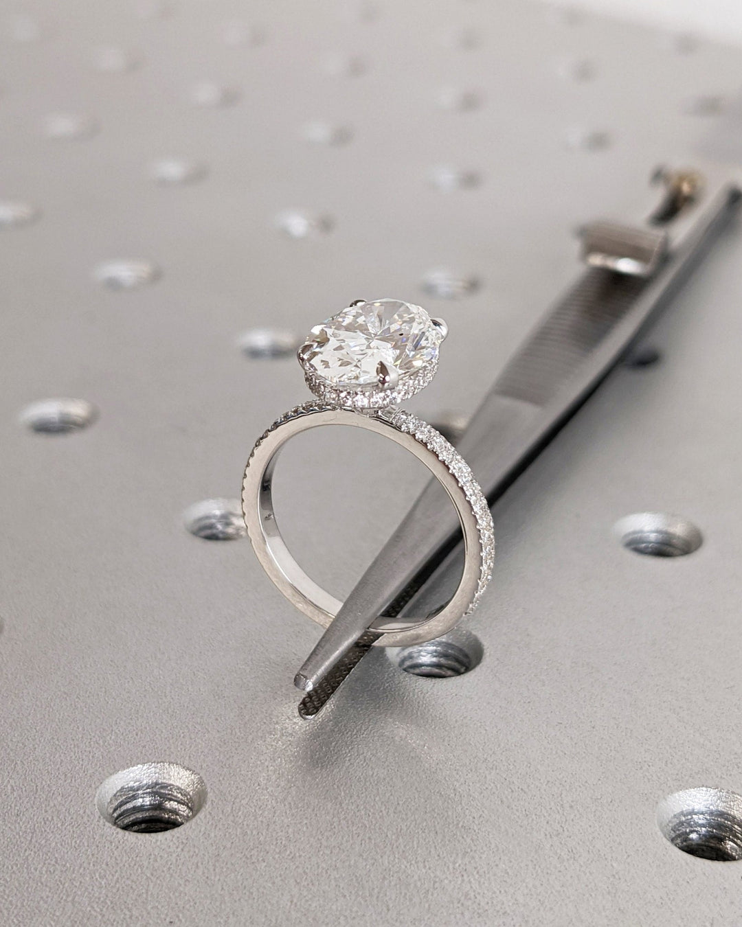 Oval hidden halo diamond ring presented in signature gift packaging