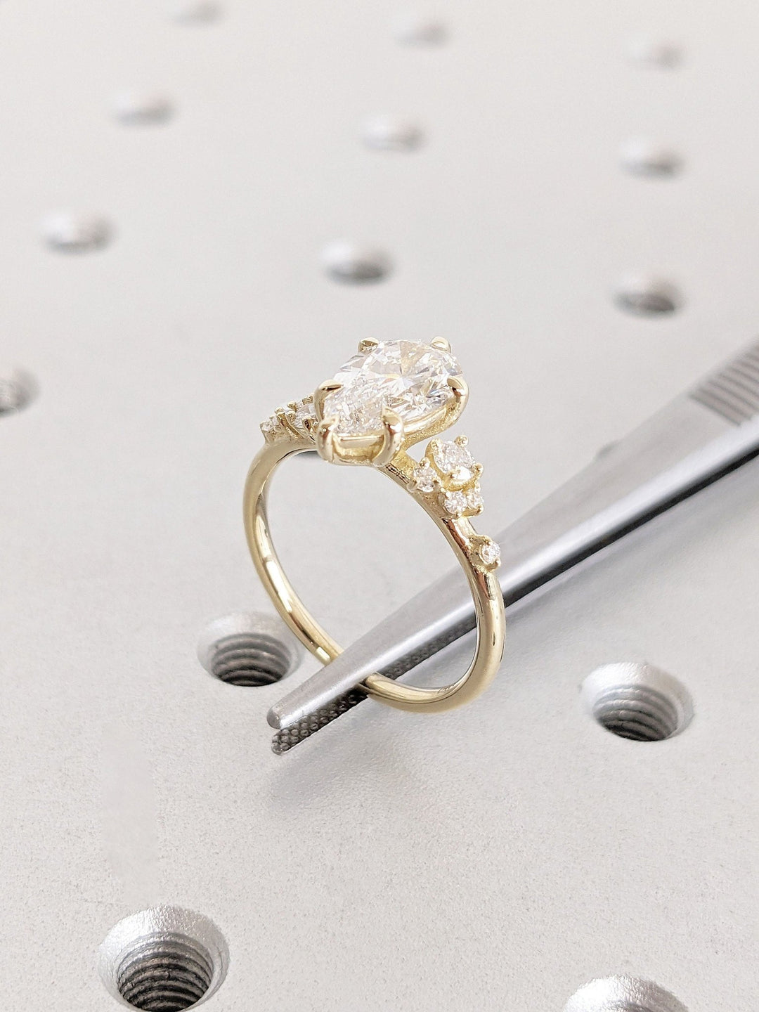 Pear cluster diamond ring displayed on jewelry stand