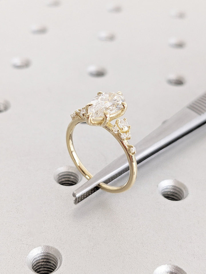 Pear cluster diamond ring displayed on jewelry stand