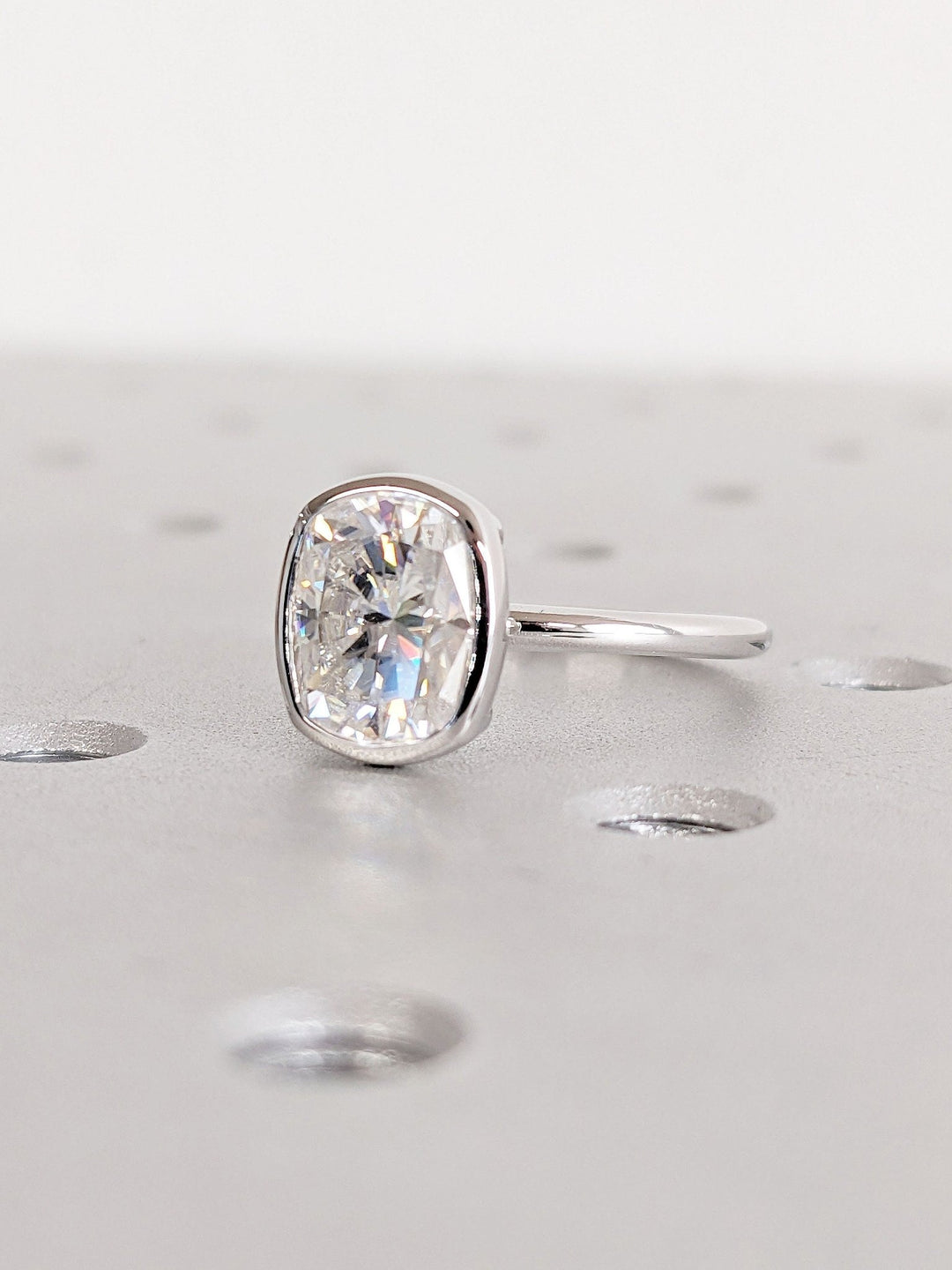 Angled view of cushion cut diamond in bezel setting
