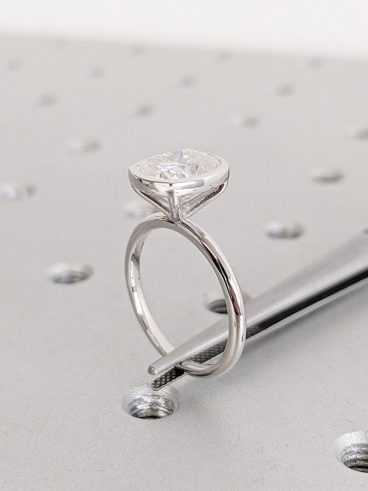 Close-up of cushion cut center diamond in bezel engagement ring