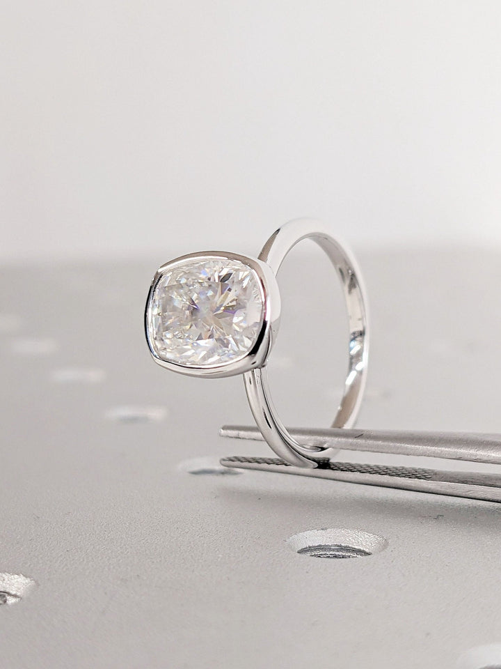 Macro shot of cushion cut diamond facets in bezel ring setting