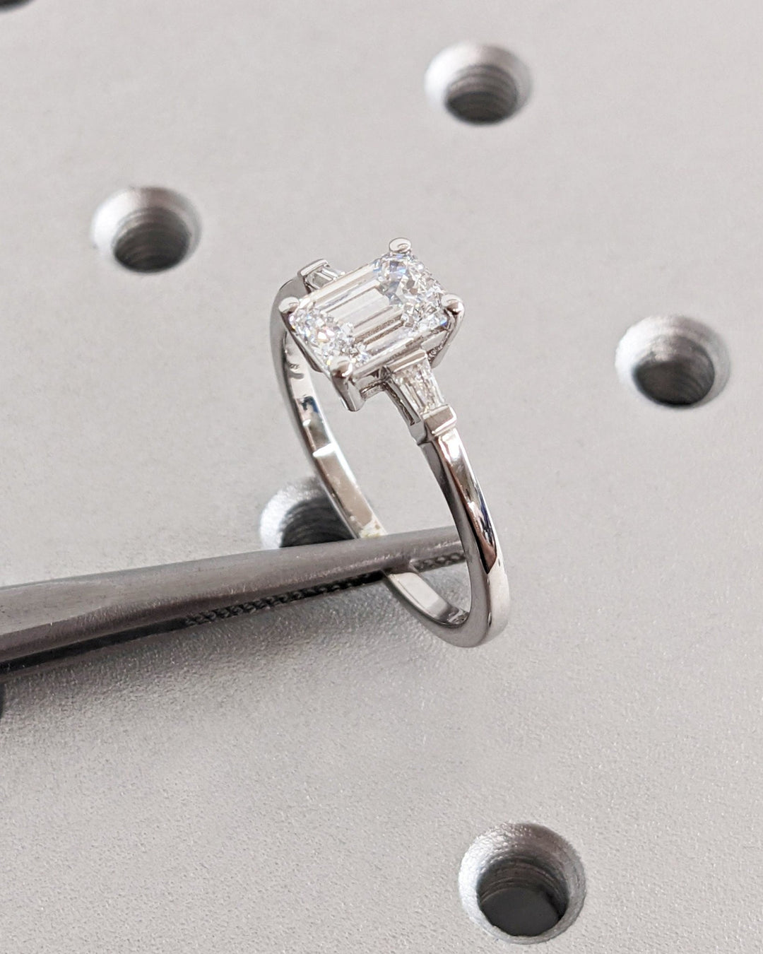 Emerald three stone engagement ring with brilliant diamond sparkle