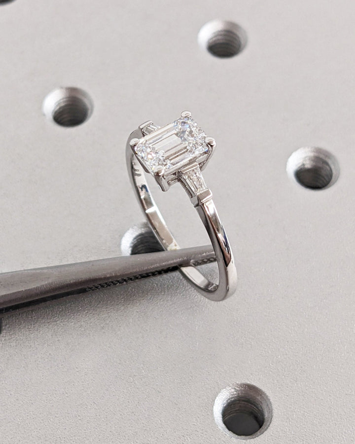 Emerald three stone engagement ring with brilliant diamond sparkle