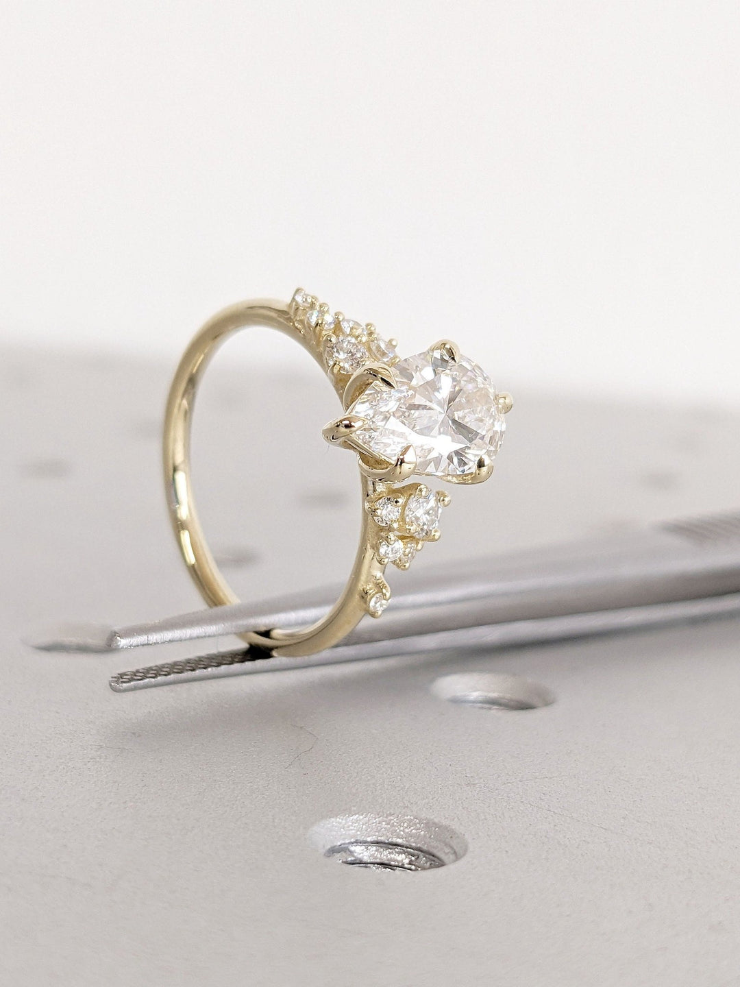 Angled view of pear cut diamond in cluster setting