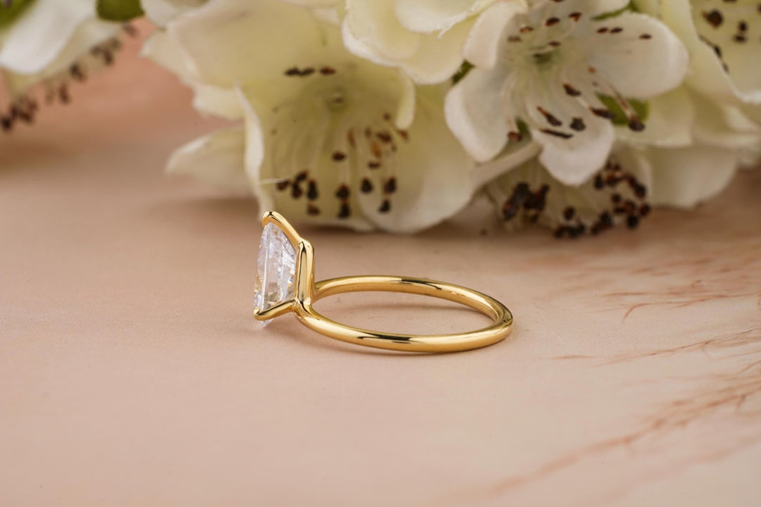 Pear solitaire engagement ring shown on hand for true-to-life sizing