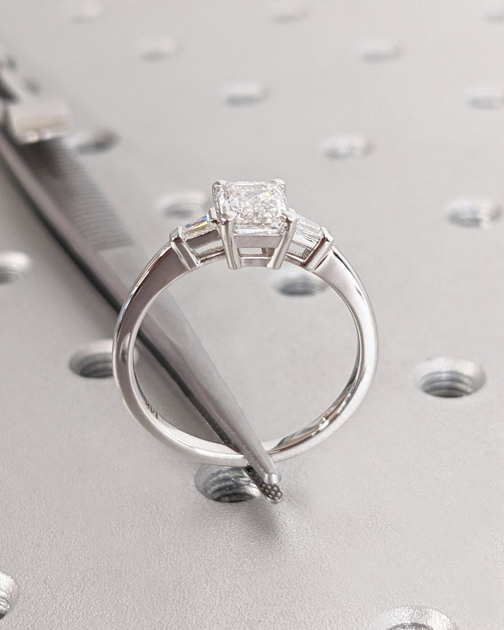 Macro shot of emerald cut diamond facets in three stone ring setting