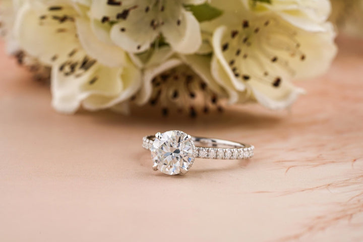 Round hidden halo engagement ring shown on hand for true-to-life sizing