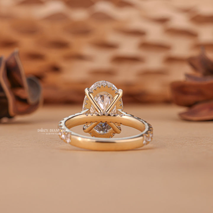 Oval hidden halo engagement ring viewed from the side