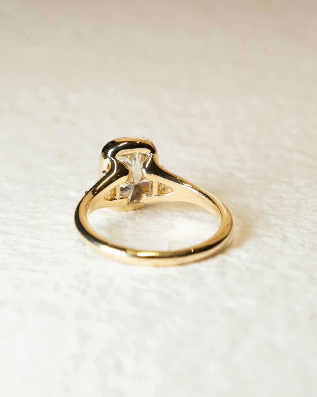 Close-up of cushion cut center diamond in bezel engagement ring