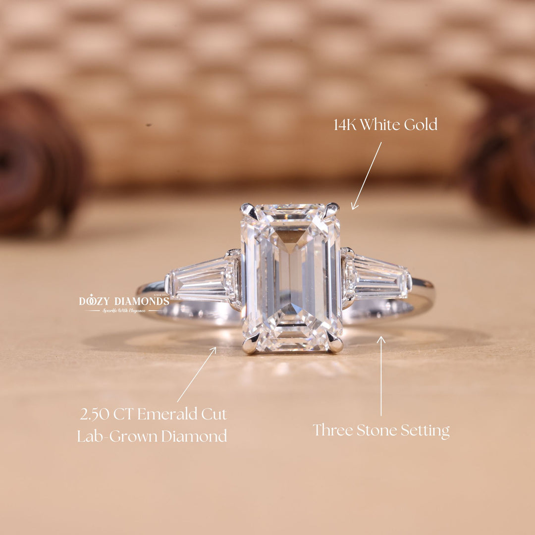 Emerald three stone diamond ring displayed on jewelry stand