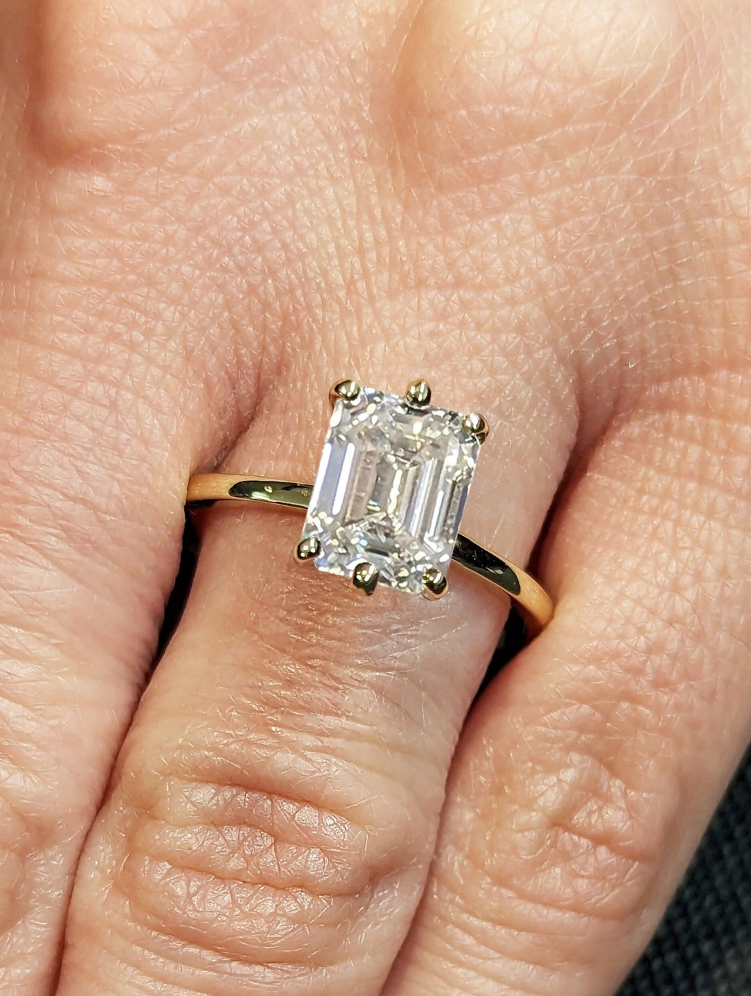 Emerald solitaire lab grown diamond ring side profile in gold setting