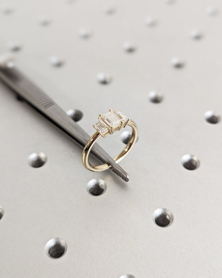Fine craftsmanship detail on emerald three stone engagement ring