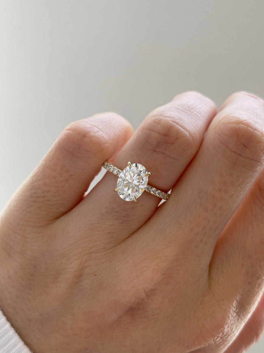 pave band diamond ring, solitaire oval engagement ring, minimalist engagement ring, classic engagement ring style, contemporary diamond ring, luxury bridal ring, proposal diamond ring, engagement ring centerpiece, white gold engagement ring, yellow gold diamond ring,