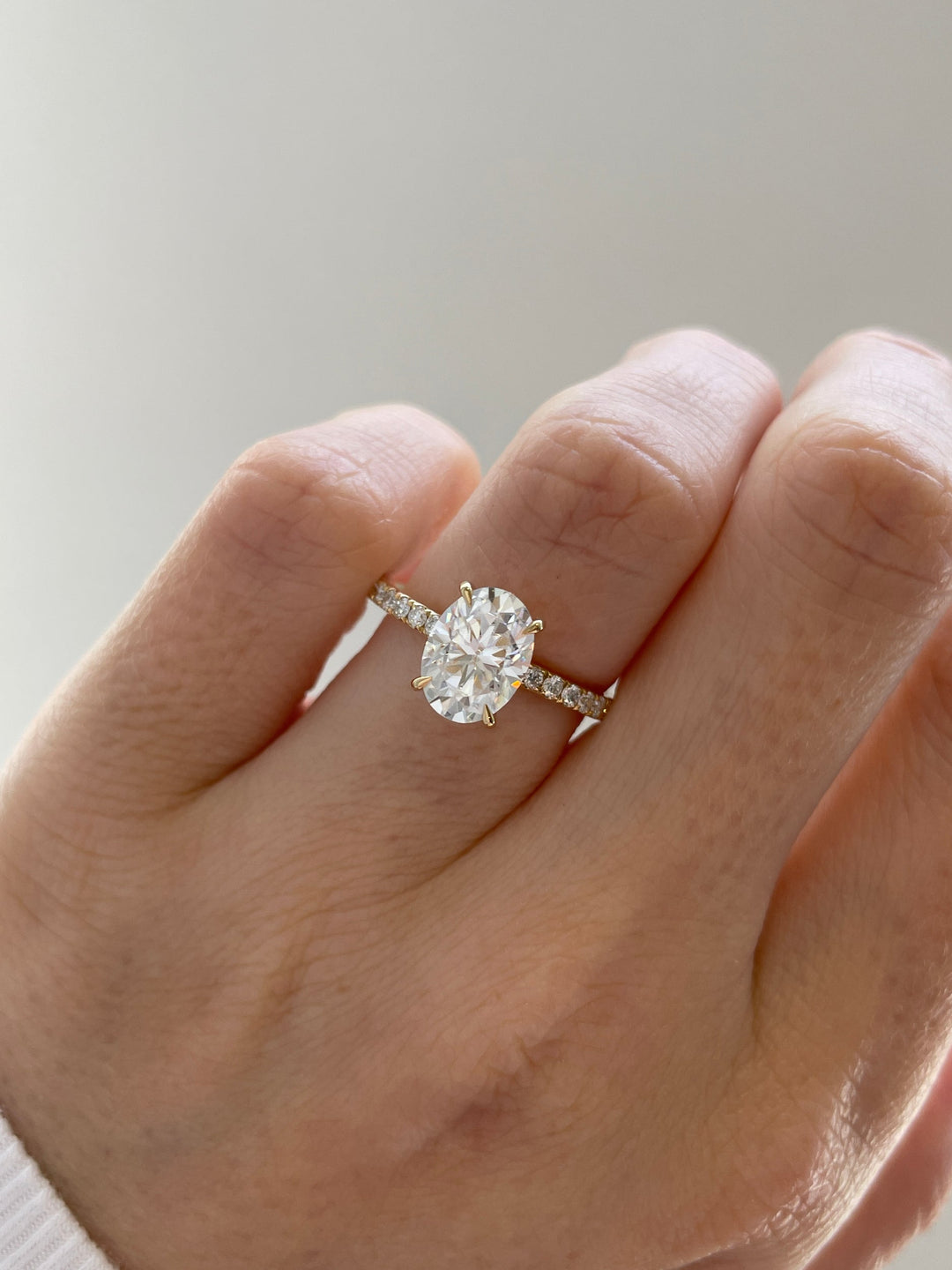 pave band diamond ring, solitaire oval engagement ring, minimalist engagement ring, classic engagement ring style, contemporary diamond ring, luxury bridal ring, proposal diamond ring, engagement ring centerpiece, white gold engagement ring, yellow gold diamond ring,