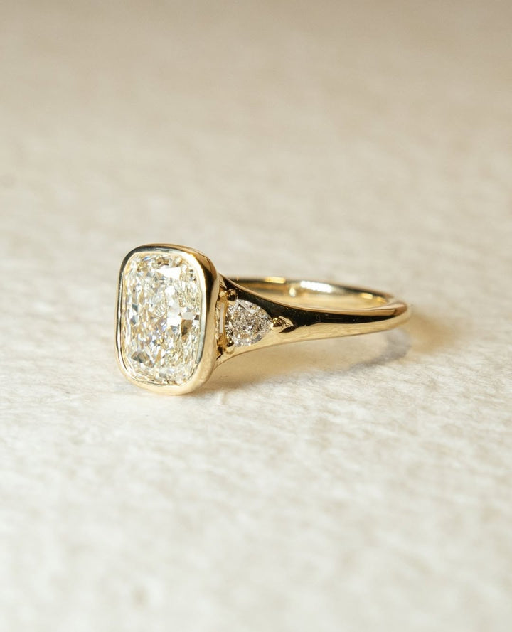 Cushion bezel engagement ring close-up highlighting diamond sparkle