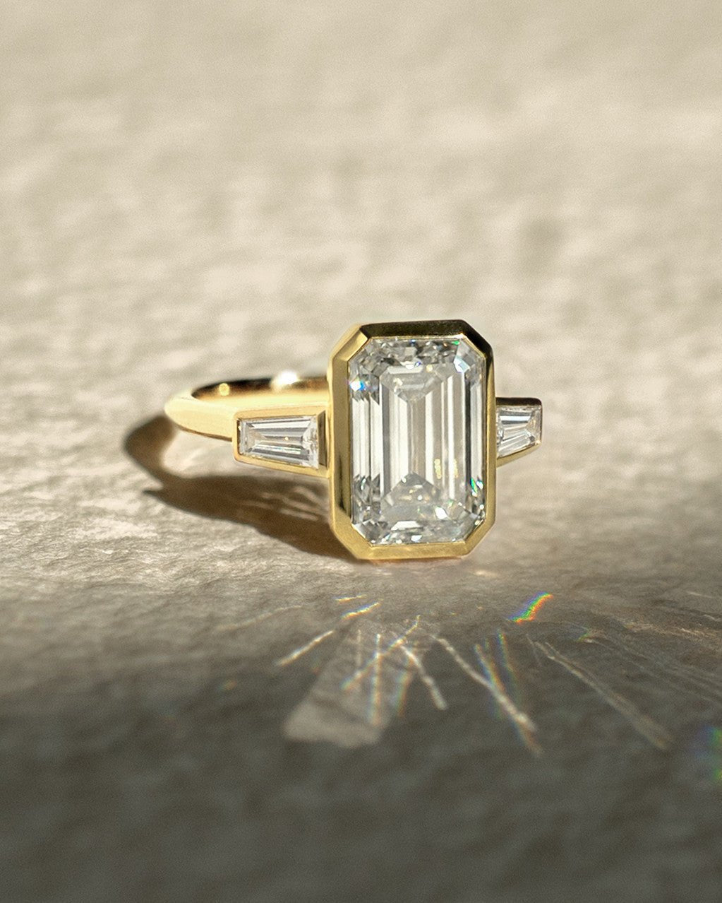 Close-up of emerald cut center diamond in bezel engagement ring