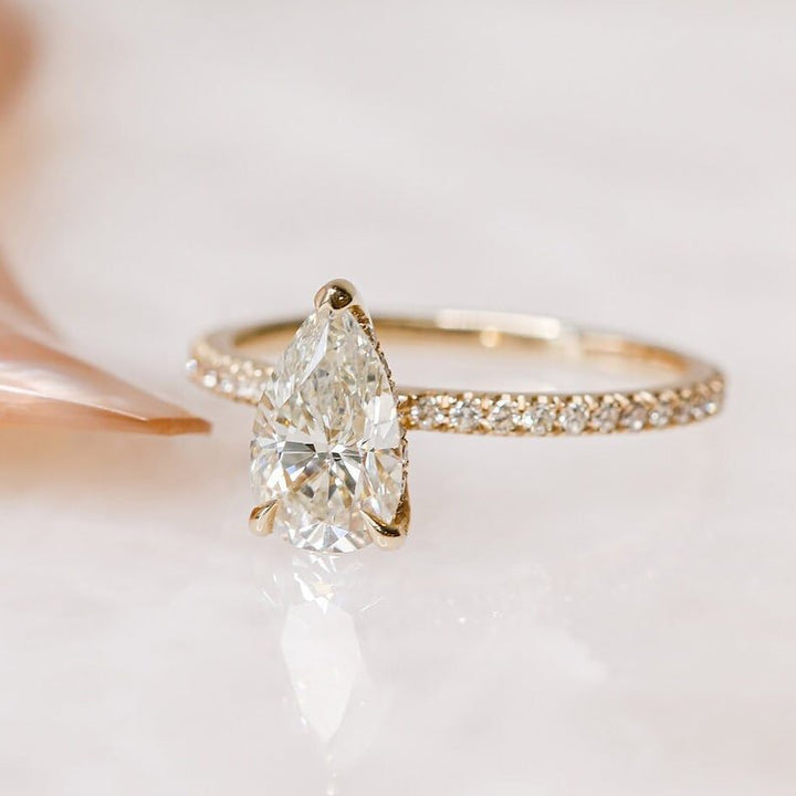 Detailed close-up of pear hidden halo diamond engagement ring