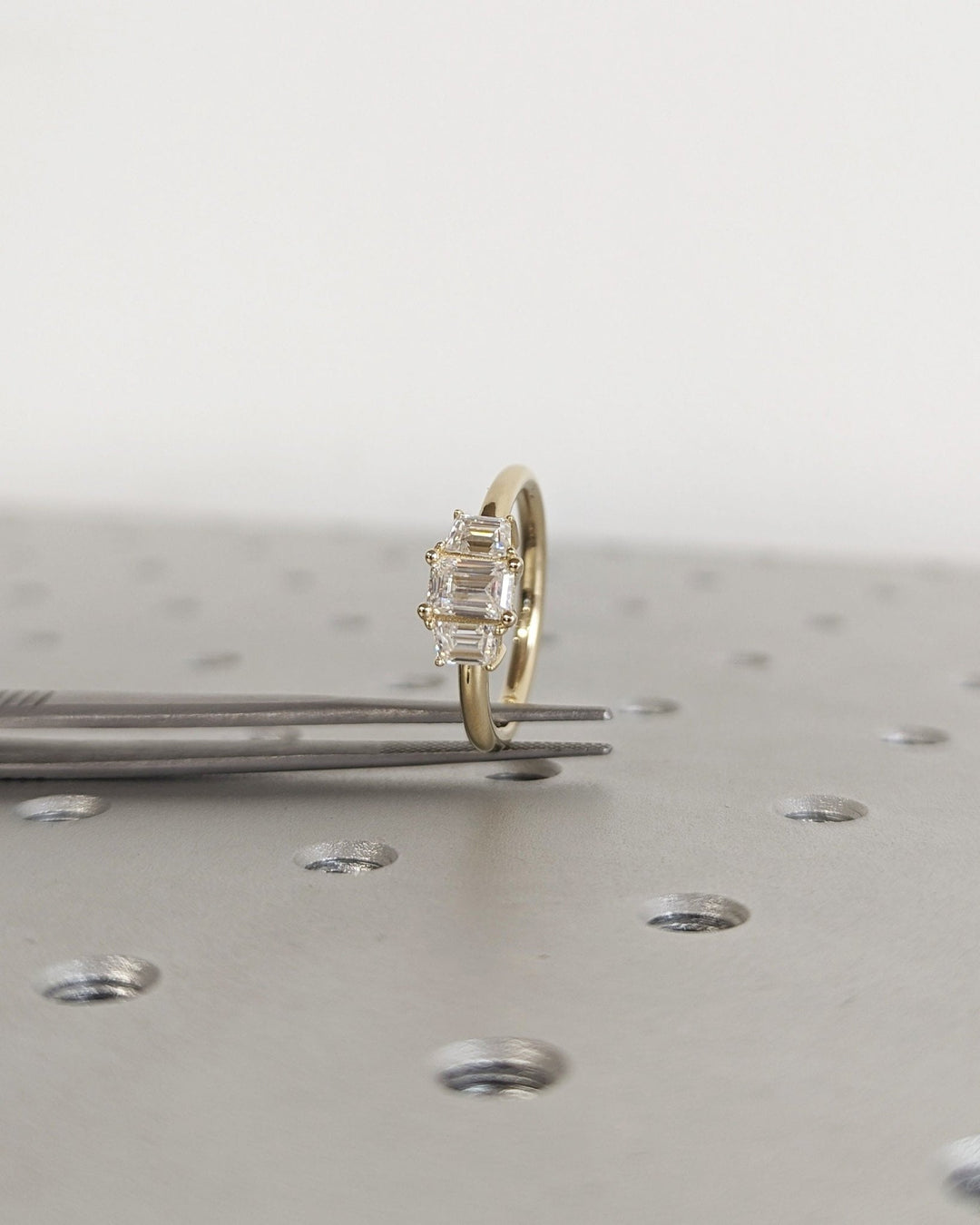 Emerald three stone engagement ring finished in polished solid gold